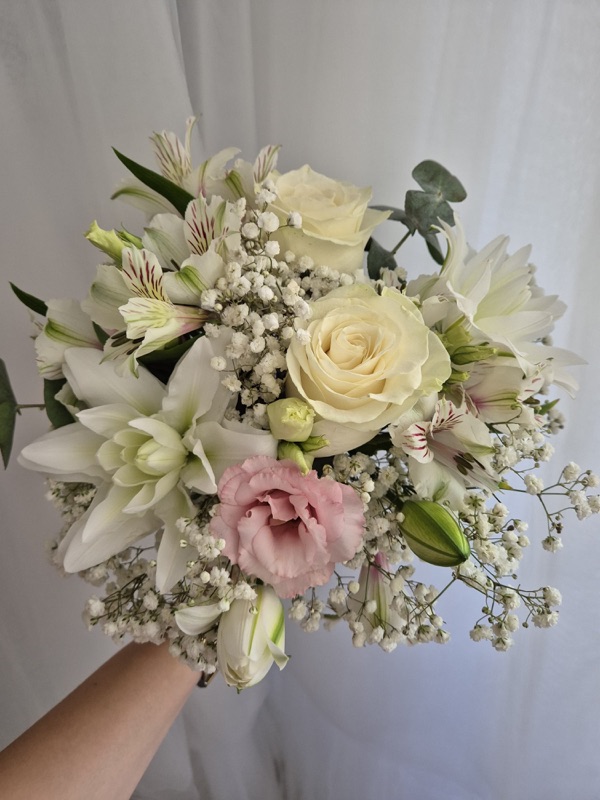 Buchet alb și roz cu trandafiri, lisianthus și floarea-miresei, ținut în mână